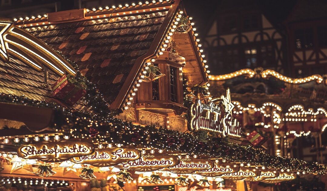 Christmas tree and market stalls in Prague's Old Town Square with the Týn Church at dusk